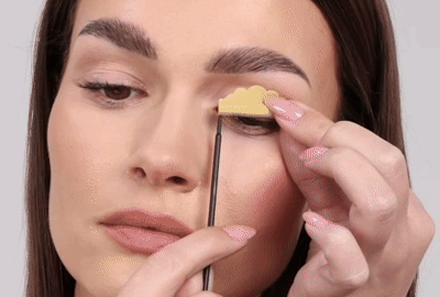 Modèle enlevant doucement les tiges de ses paupières et de ses cils